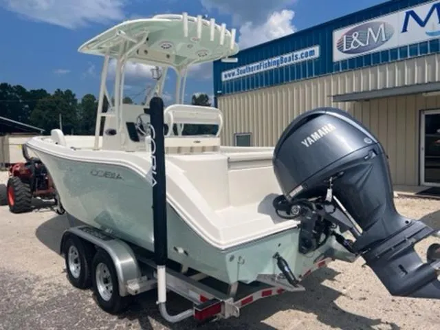 Slide: The Image of 2024 Cobia 220 CC boat with Yamaha engine on a trailer, parked outside a dealership. - 4