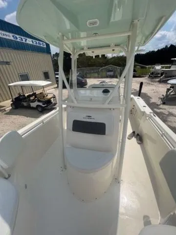 Slide: The Image of 2024 Cobia 220 CC boat with center console, parked outdoors under a clear sky. - 5