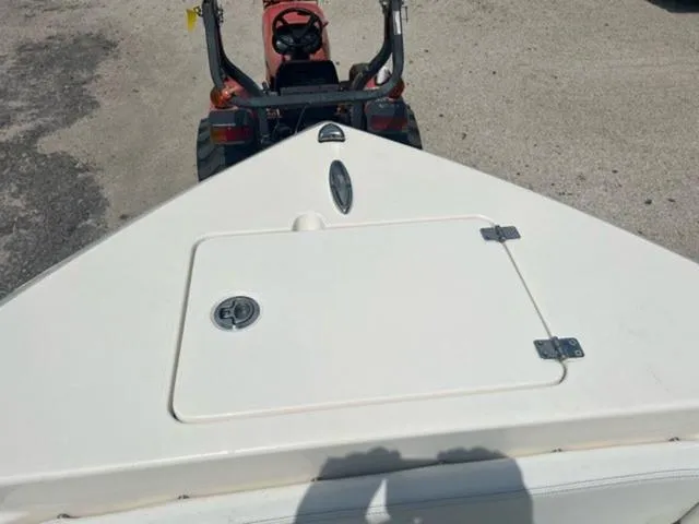 Slide: The Image of 2024 Cobia 220 CC boat bow with hatch, parked on a trailer. - 7
