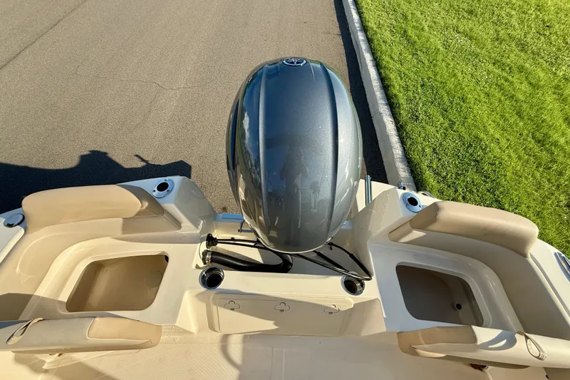 Slide: The Image of 2025 Scout 195 Sport Dorado boat with outboard motor, beige seating, and storage compartments. - 10