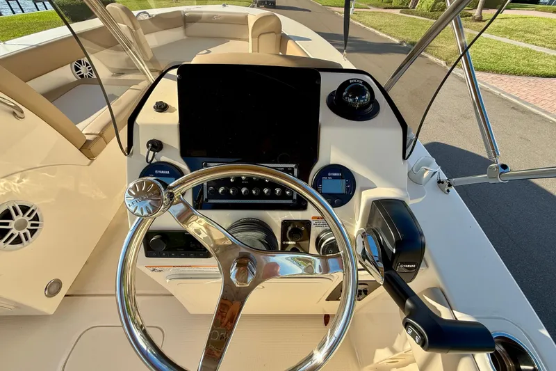 Slide: The Image of 2025 Scout 195 Sport Dorado boat dashboard with steering wheel and controls. - 17