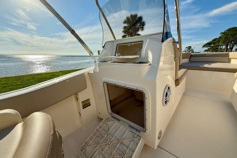 Slide: The Image of 2025 Scout 195 Sport Dorado boat interior with open storage, scenic waterfront view. - 22