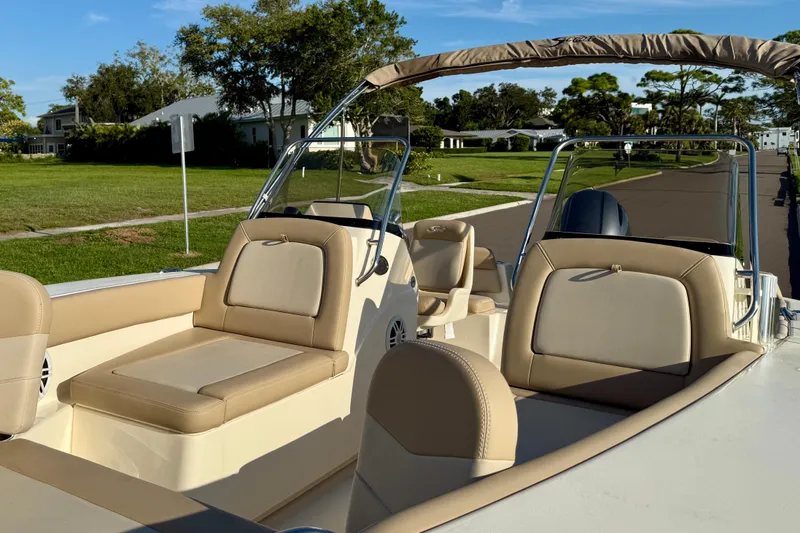 Slide: The Image of 2025 Scout 195 Sport Dorado boat with beige seating, parked in a residential area. - 29