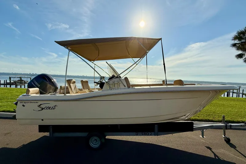 Slide: The Image of 2025 Scout 195 Sport Dorado boat on trailer by waterfront, sunny day. - 3
