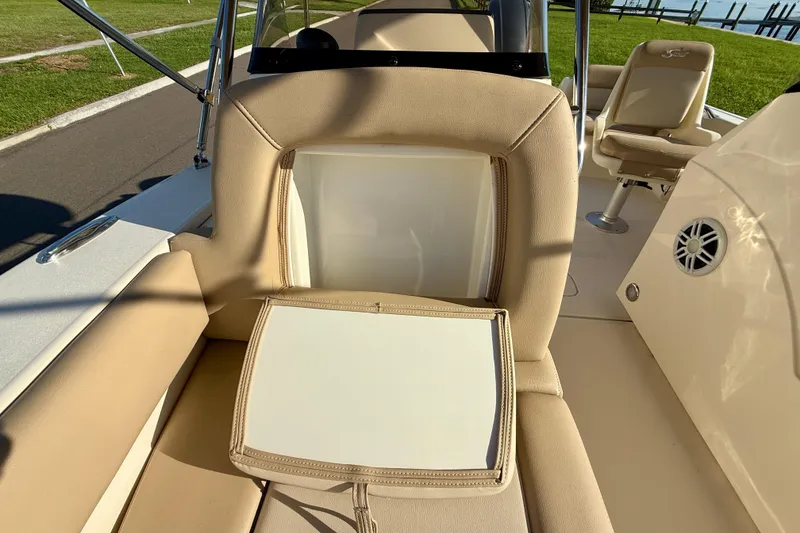 Slide: The Image of 2025 Scout 195 Sport Dorado boat interior with beige seating and storage compartment. - 33