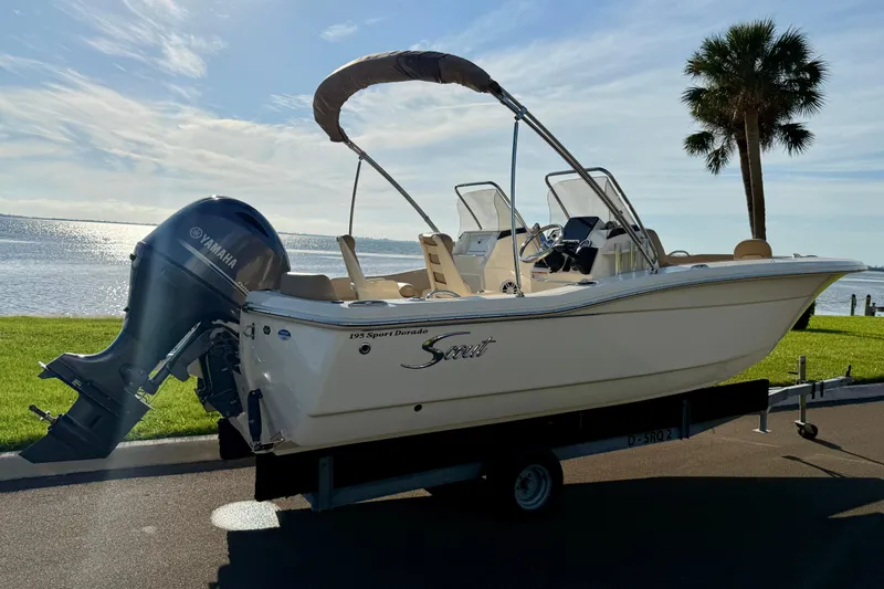 Slide: The Image of 2025 Scout 195 Sport Dorado boat with Yamaha engine by a scenic waterfront. - 5