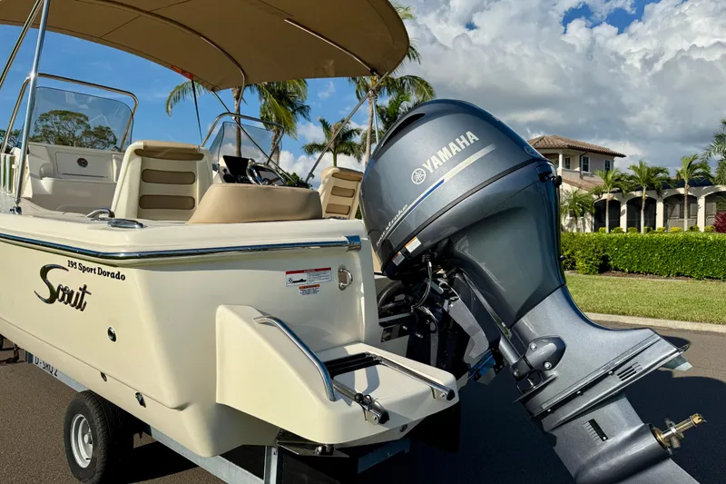 Slide: The Image of 2025 Scout 195 Sport Dorado boat with Yamaha engine, parked near tropical residence. - 8