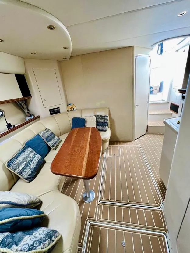 Slide: The Image of 2000 Cruisers Yachts 3772 Express interior with plush seating and elegant wood table. - 10