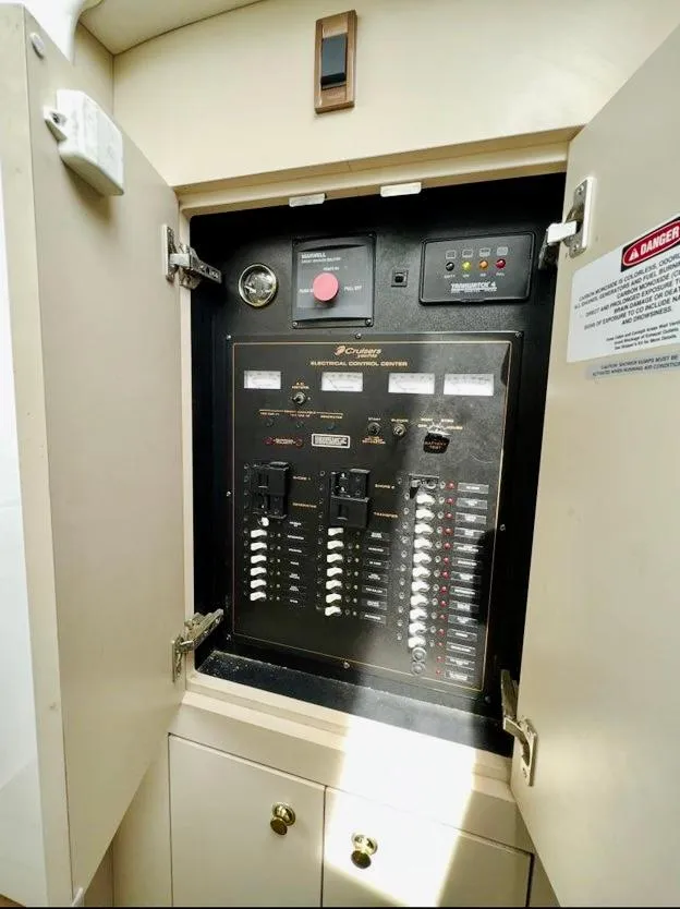 Slide: The Image of Electrical panel inside 2000 Cruisers Yachts 3772 Express, with open cabinet doors. - 7