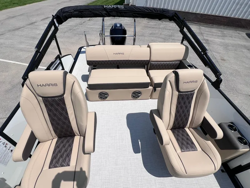 Slide: The Image of 2025 Harris Sunliner 230 boat interior with beige and black seating, featuring cup holders. - 10