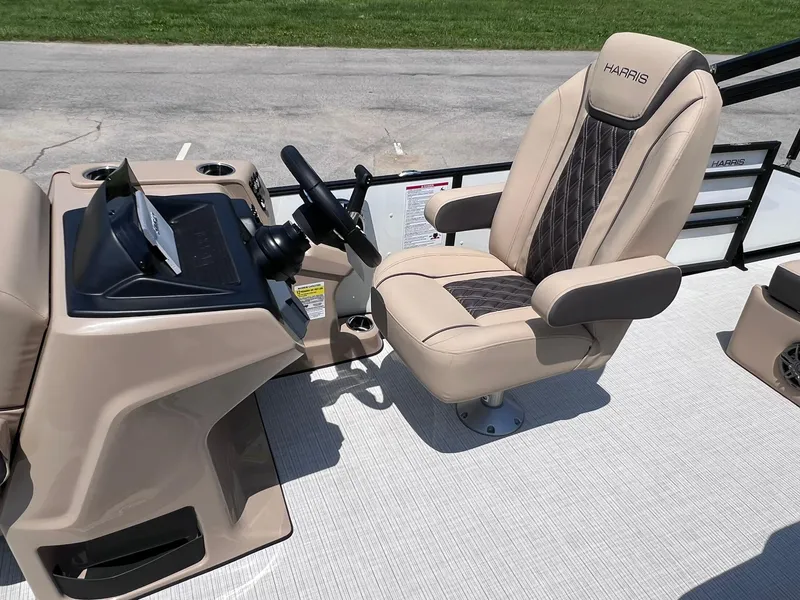 Slide: The Image of 2025 Harris Sunliner 230 boat interior with beige captain's chair and steering console. - 12