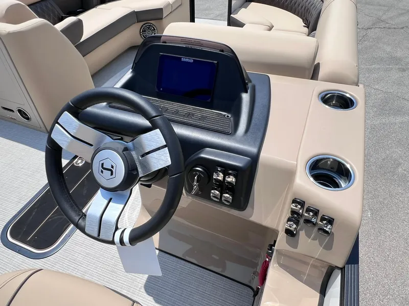 Slide: The Image of 2025 Harris Sunliner 230 boat dashboard with steering wheel and control panel. - 17
