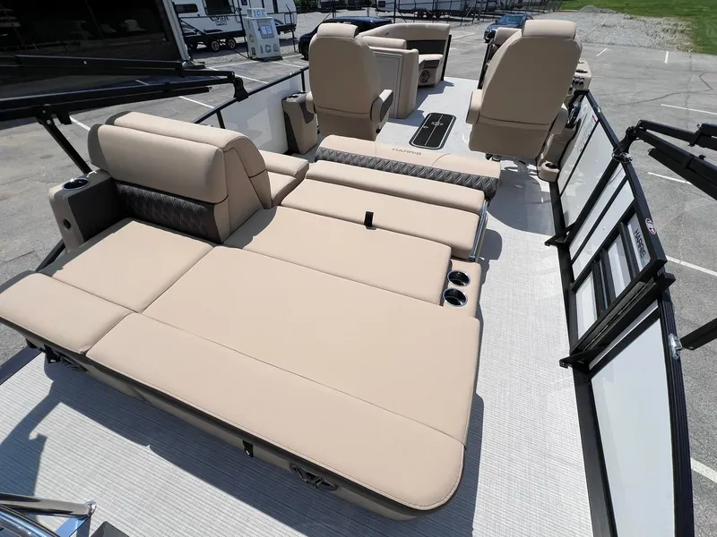 Slide: The Image of 2025 Harris Sunliner 230 boat interior with beige seating and cup holders. - 21