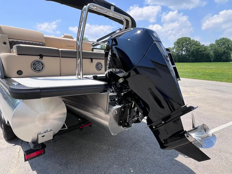 Slide: The Image of 2025 Harris Sunliner 230 pontoon boat with powerful outboard motor, parked on sunny day. - 29