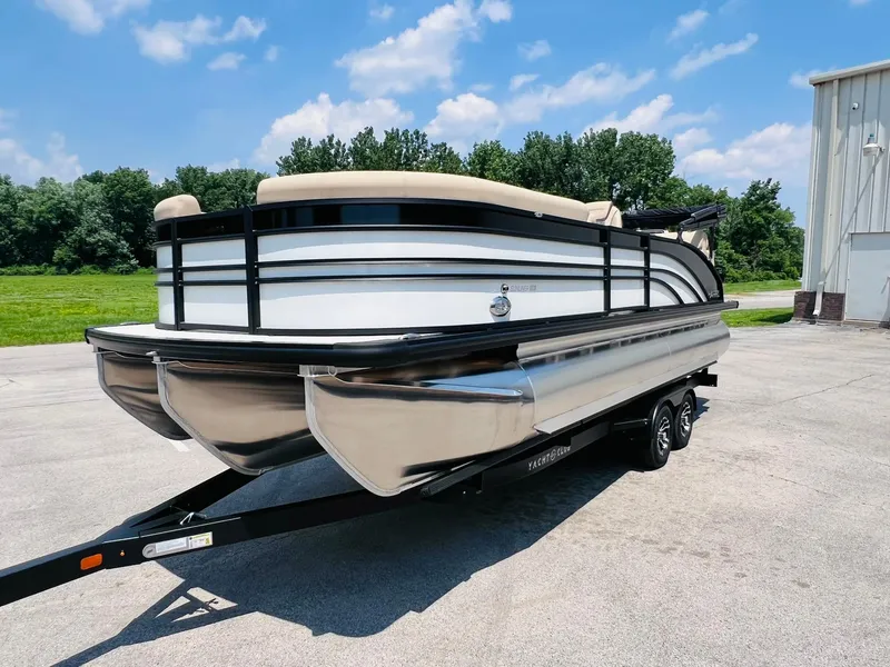 Slide: The Image of 2025 Harris Sunliner 230 pontoon boat on trailer, outdoors under blue sky. - 4