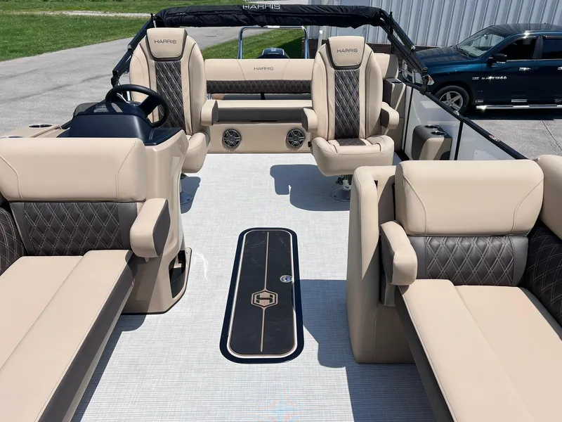 Slide: The Image of 2025 Harris Sunliner 230 boat interior with beige and black seating, modern design. - 8