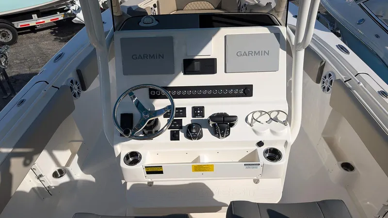 Slide: The Image of 2025 Key West 263 FS boat dashboard with Garmin navigation systems and steering wheel. - 9