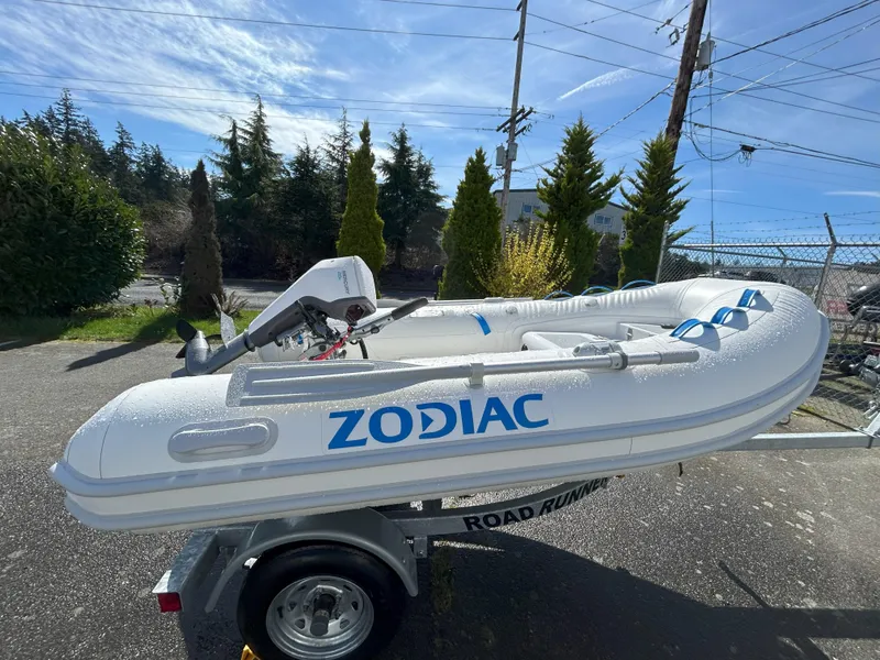 Slide: The Image of 2024 Zodiac Nomad 3.1 RIB Alu boat on trailer, outdoors, sunny day. - 2