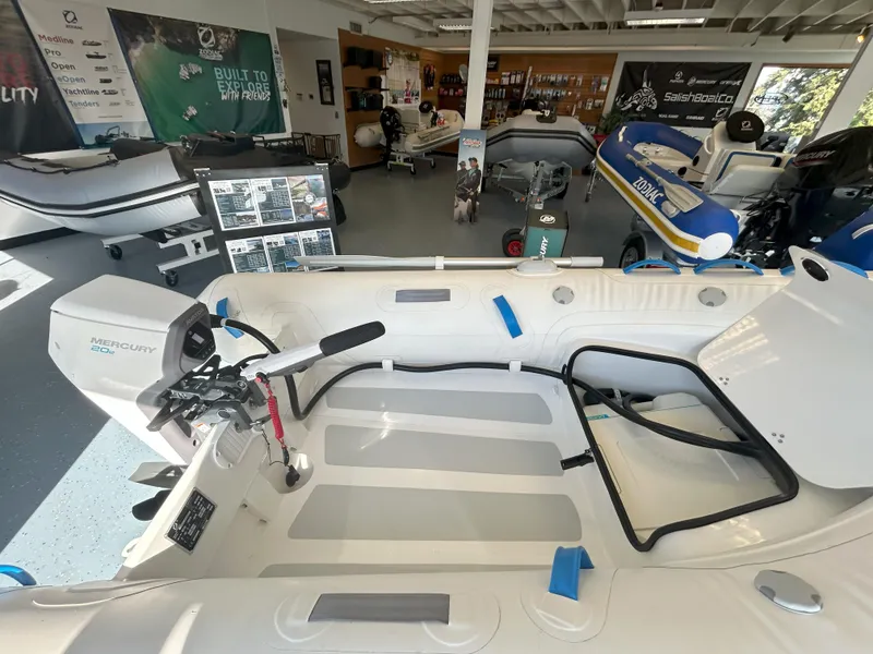 Slide: The Image of 2024 Zodiac Nomad 3.1 RIB Alu boat in showroom, featuring Mercury engine and modern design. - 3