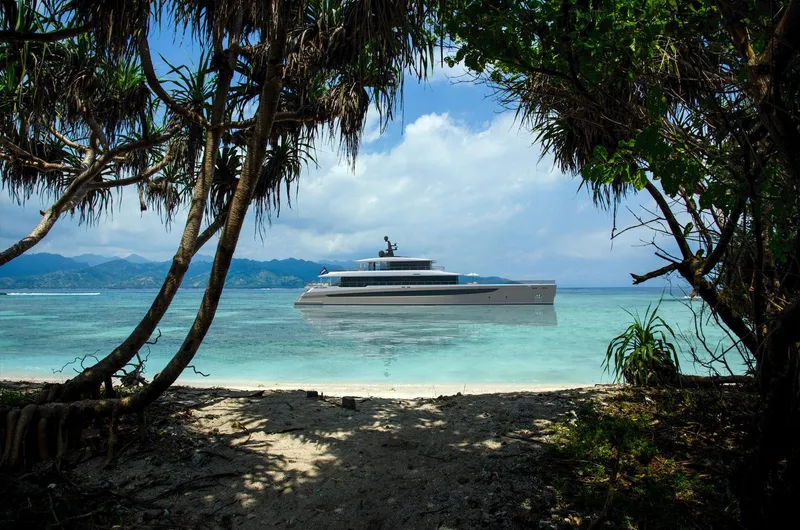Slide: The Image of Luxurious 2026 Prime Megayacht NEXT anchored near tropical island, framed by lush greenery. - 5