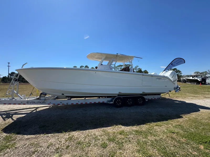 Slide: The Image of 2023 Invincible 37 Catamaran on trailer under clear blue sky. - 1