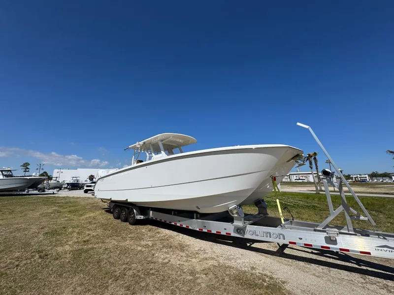 Slide: The Image of 2023 Invincible 37 Catamaran on trailer under clear blue sky. - 10