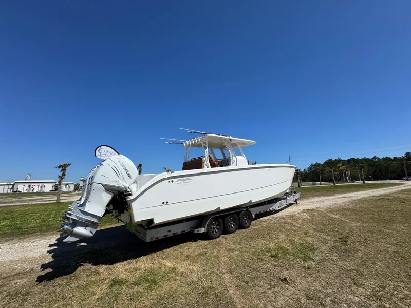 Slide: The Image of 2023 Invincible 37 Catamaran on trailer under clear blue sky. - 15