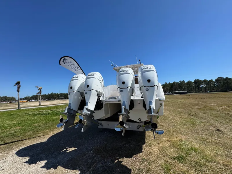 Slide: The Image of 2023 Invincible 37 Catamaran with four powerful outboard engines, displayed outdoors under clear blue sky. - 18