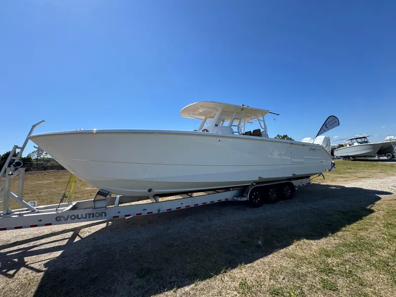 Slide: The Image of 2023 Invincible 37 Catamaran on trailer under clear blue sky. - 2