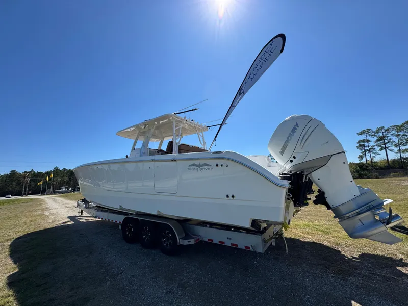 Slide: The Image of 2023 Invincible 37 Catamaran on trailer under clear blue sky. - 21