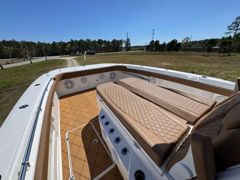 Slide: The Image of 2023 Invincible 37 Catamaran with tan seating and spacious deck in a scenic outdoor setting. - 25