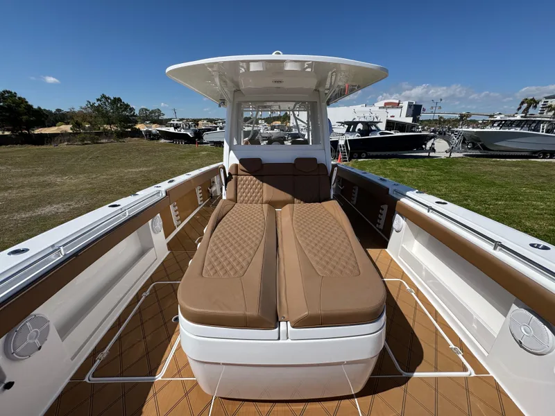 Slide: The Image of 2023 Invincible 37 Catamaran with tan seating and spacious deck, docked outdoors. - 26