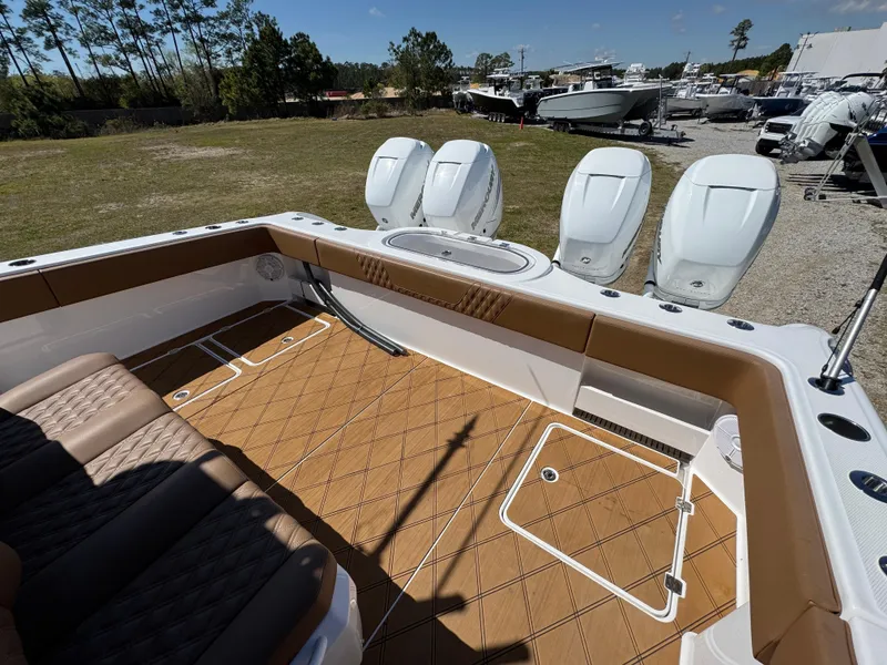 Slide: The Image of 2023 Invincible 37 Catamaran with tan deck, triple outboard engines, and spacious seating area. - 37