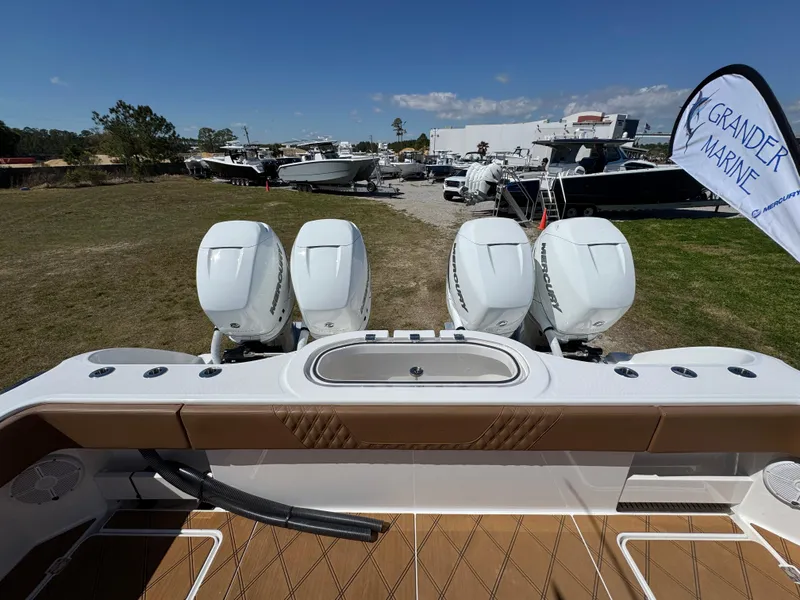 Slide: The Image of 2023 Invincible 37 Catamaran with four powerful outboard engines, displayed at a marine dealership. - 38