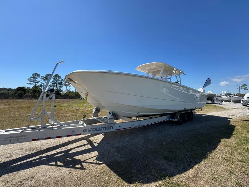 Slide: The Image of 2023 Invincible 37 Catamaran on trailer under clear blue sky. - 4