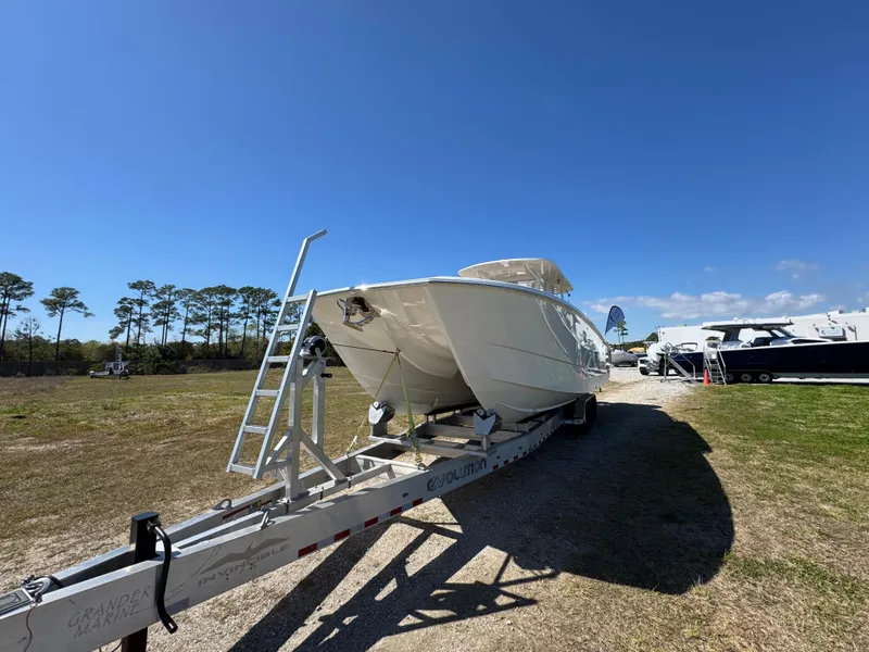 Slide: The Image of 2023 Invincible 37 Catamaran on trailer under clear blue sky. - 6