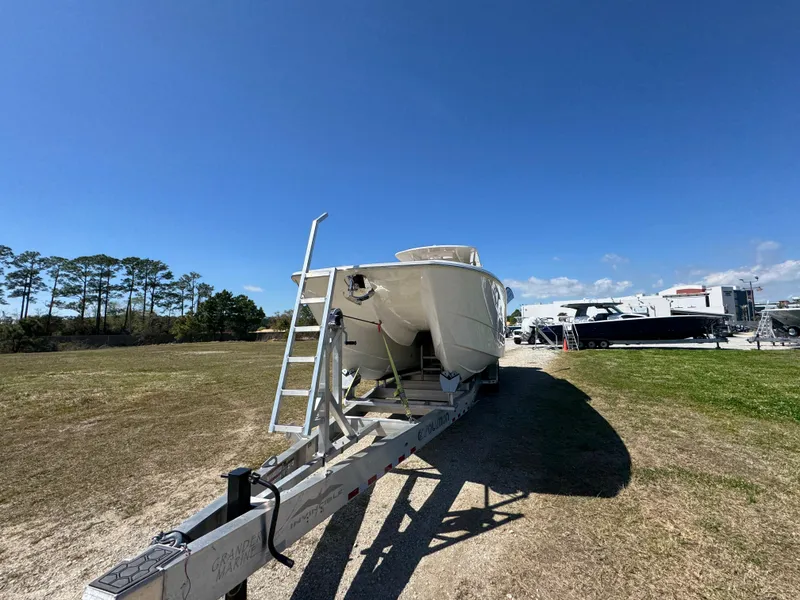 Slide: The Image of 2023 Invincible 37 Catamaran on trailer under clear blue sky. - 7