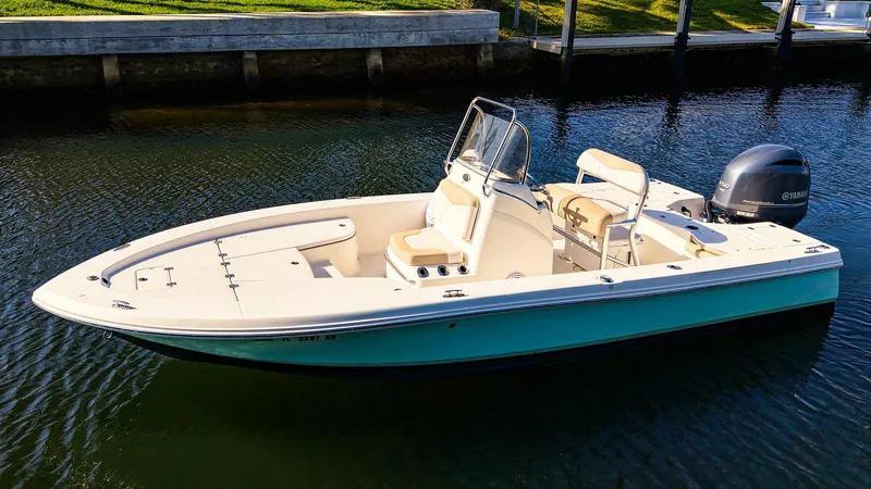 Slide: The Image of 2016 Robalo 206 Cayman boat on calm water, featuring sleek design and outboard motor. - 0