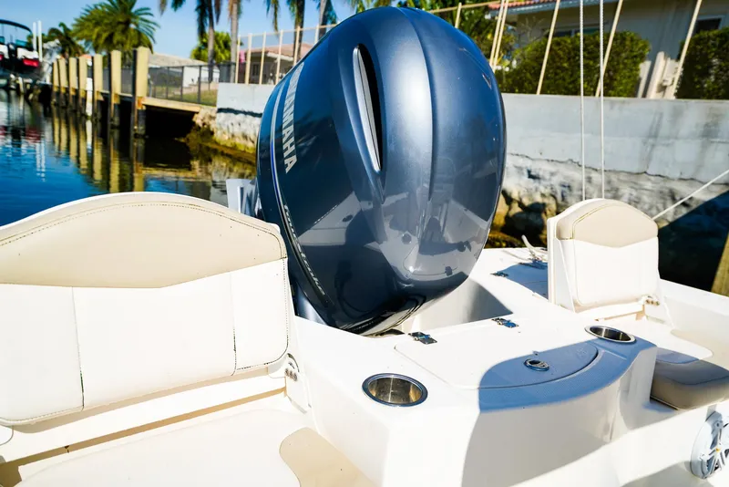 Slide: The Image of 2016 Robalo 206 Cayman boat with Yamaha engine, docked near palm trees. - 13
