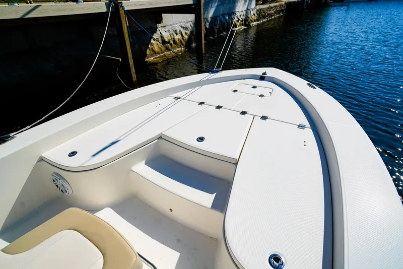 Slide: The Image of 2016 Robalo 206 Cayman boat deck by the water, showcasing seating and storage. - 3