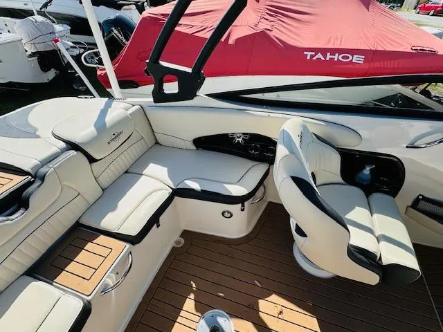Slide: The Image of 2021 Stingray 225 SE boat interior with beige seating and wood flooring. - 11
