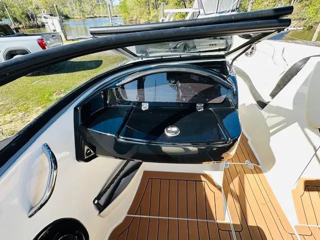 Slide: The Image of 2021 Stingray 225 SE boat interior with open storage compartment and teak flooring. - 14