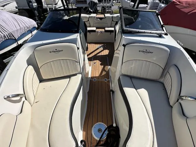 Slide: The Image of 2021 Stingray 225 SE boat interior with white seating and wood flooring. - 23