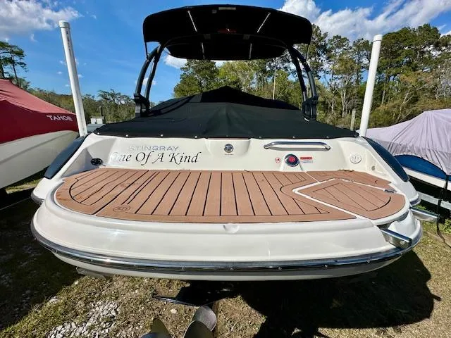 Slide: The Image of 2021 Stingray 225 SE boat with teak deck, parked outdoors under blue sky. - 5