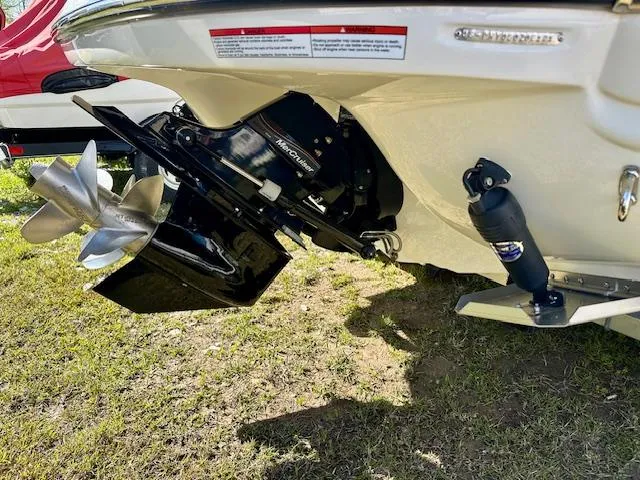 Slide: The Image of 2021 Stingray 225 SE boat stern with propeller and outdrive on grass. - 6