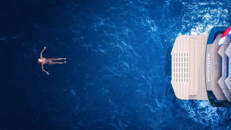 Slide: The Image of Person swimming near Waterdream California 52XT yacht, 2025 model, in deep blue ocean. - 10
