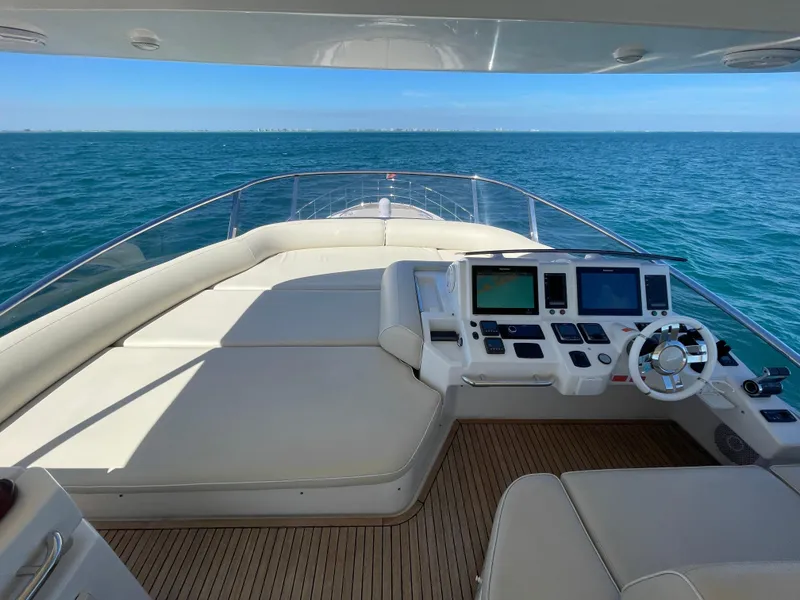 Slide: The Image of 2014 Azimut 70 yacht helm with ocean view, featuring modern navigation equipment and luxurious seating. - 26