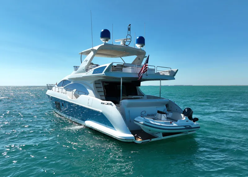 Slide: The Image of Azimut 70 yacht from 2014 on open water, featuring a small boat on the deck. - 7