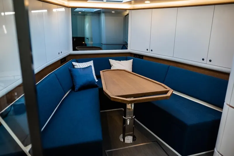 Slide: The Image of Luxurious interior of 2025 Waterdream California 52XT Hardtop with blue seating and wooden table. - 14