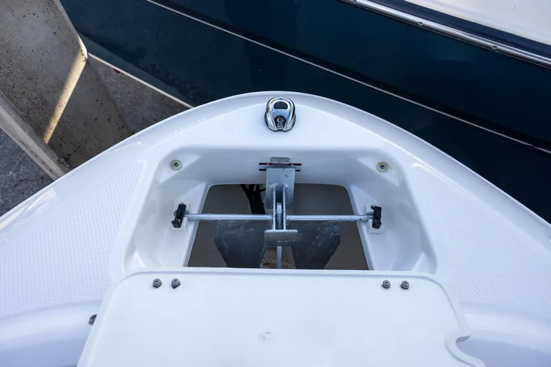 Slide: The Image of 2023 Chaparral 21 SSi OB boat anchor compartment, featuring a sleek white design. - 11